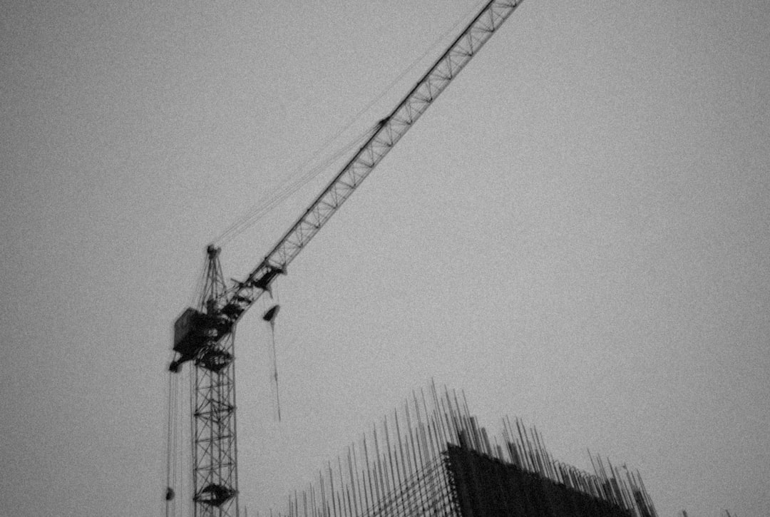 a crane is standing next to a building under construction