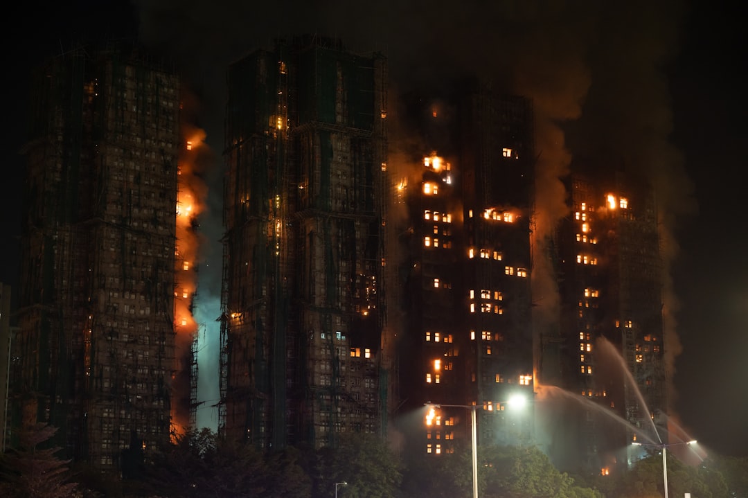 Apartment buildings engulfed in flames at night.