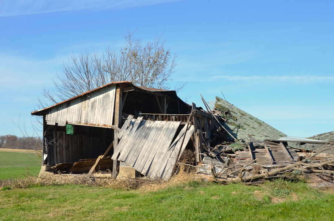 Dilapidated wooden barn under a clear blue sky