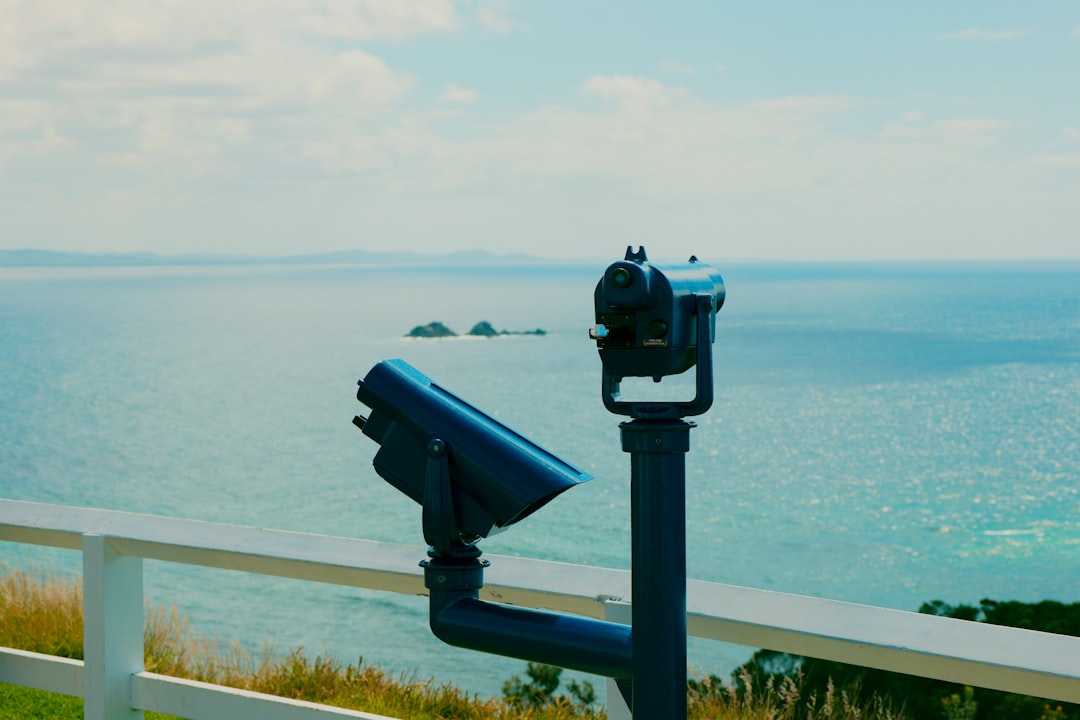 Two viewing binoculars overlook a calm ocean.