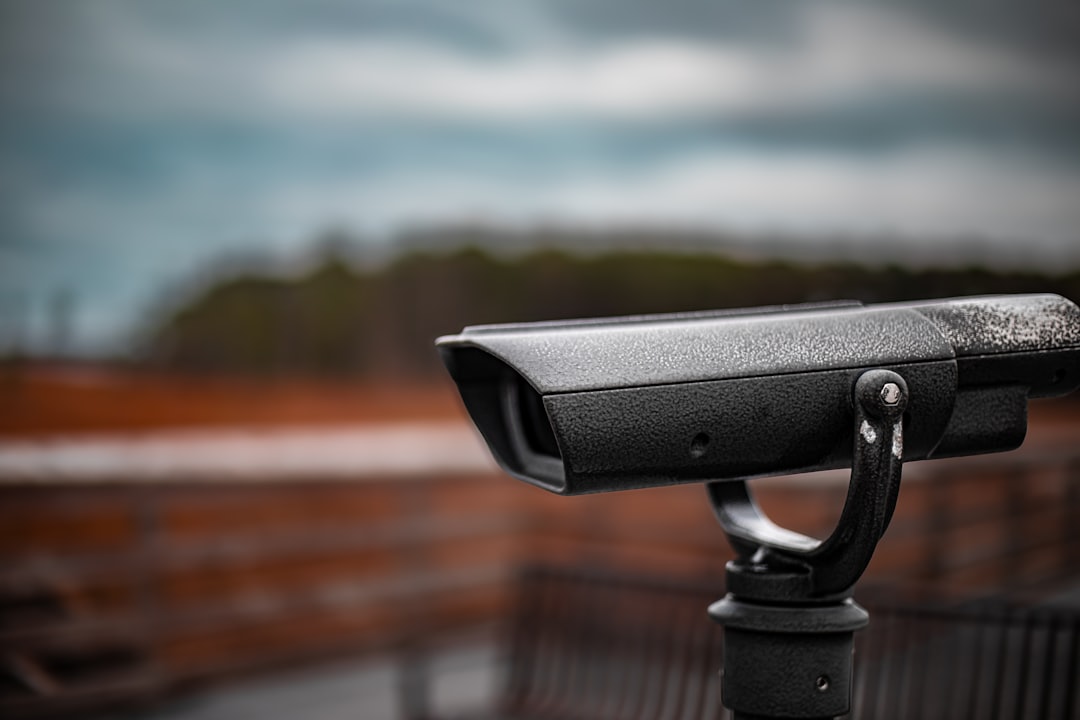 A black telescope on a stand overlooking a blurry landscape.